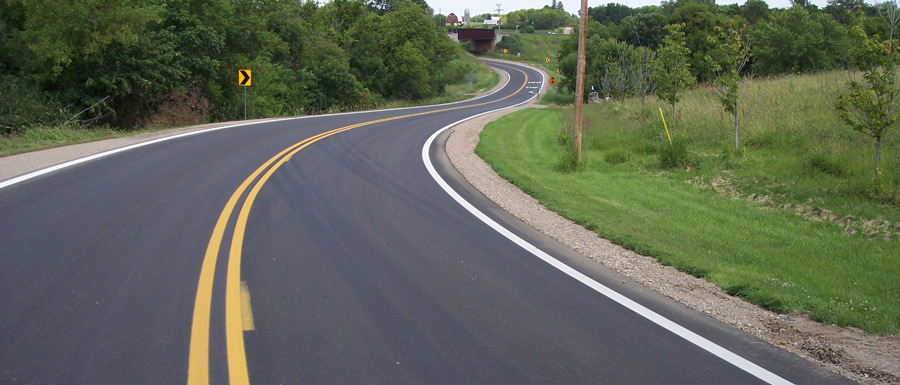 Photograph of a highway winding through trees.