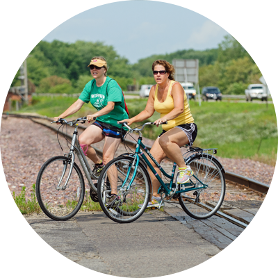 Two women biking over a rail crossing